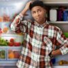confused man in front of fridge and cupboard