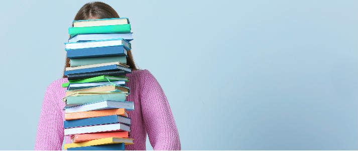 girl carrying stack of textbooks