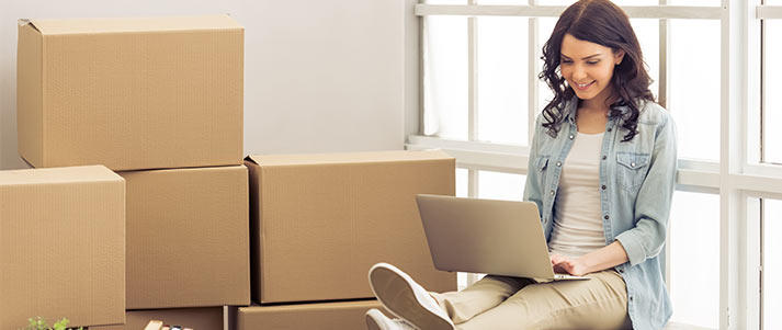 moving in boxes and girl using laptop