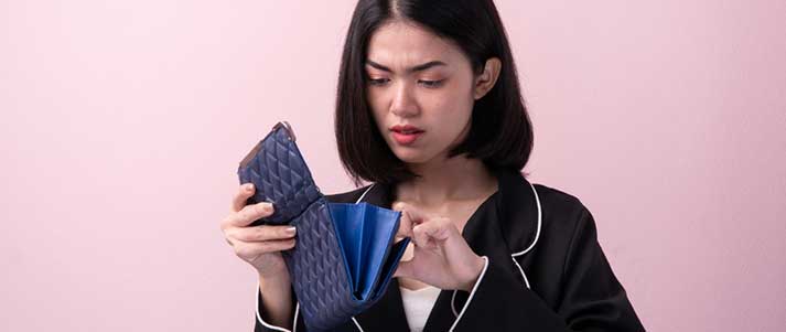 woman looking in purse frowning